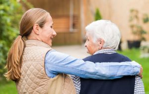 Eine Frau hält eine ältere Dame im Arm